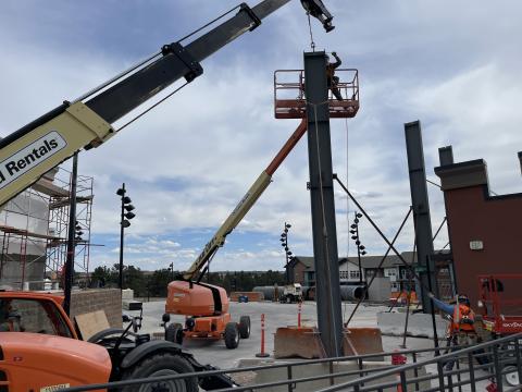 Construction on the sound walls at Ford Amphitheater begins, with a crane helping to place a steel beam.