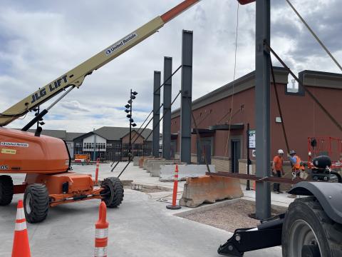 Construction on the sound walls at Ford Amphitheater begins, with a crane helping to place a steel beam.