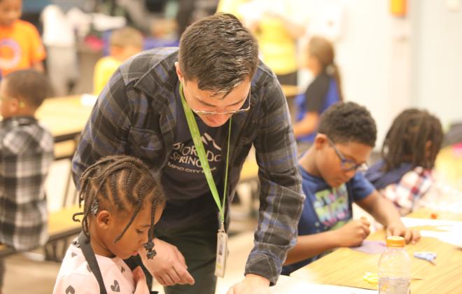 A community Center worker helps a student with their project