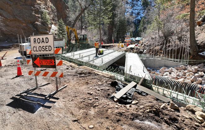 road closed sign in front of partially completed bridge